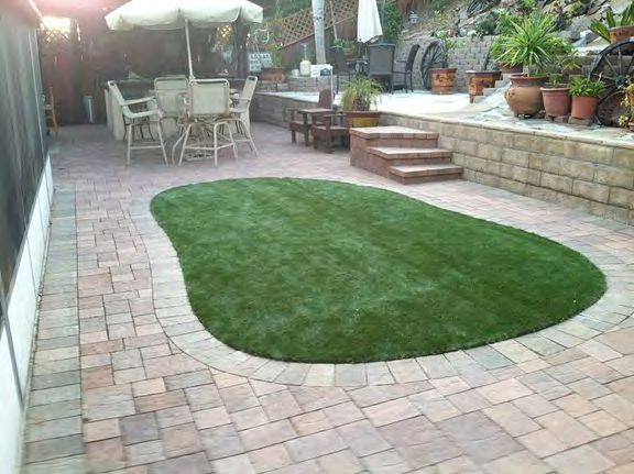Artificial turf installed around pool area for soft non-slip surface