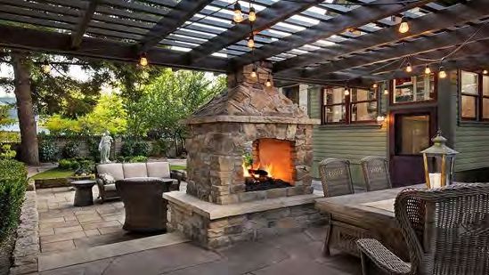 Outdoor fireplace with mantel and decorative stone surround