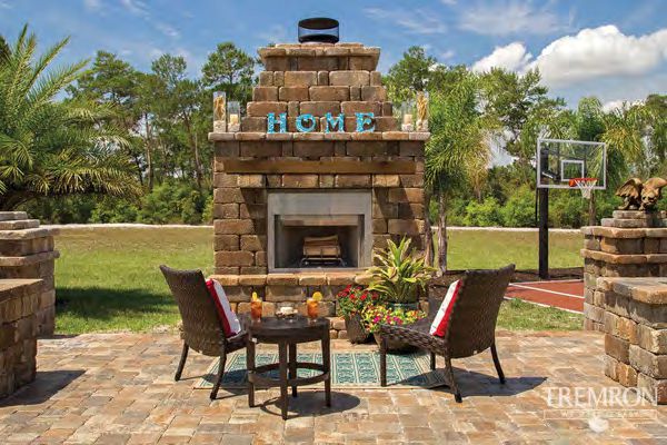 Custom built outdoor fireplace matching home architectural style