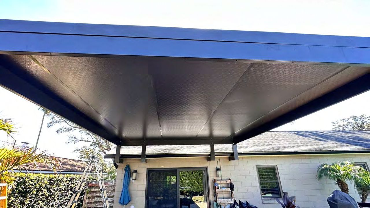 Covered patio pergola with solid roof panels for shade protection