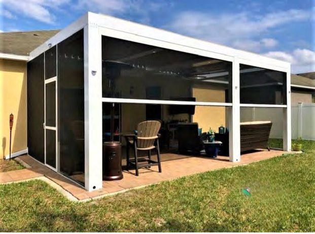 Flat roof screen enclosure covering patio and pool area in Florida