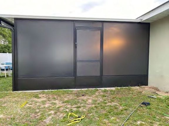 Backyard screen enclosure installed over pool deck and patio